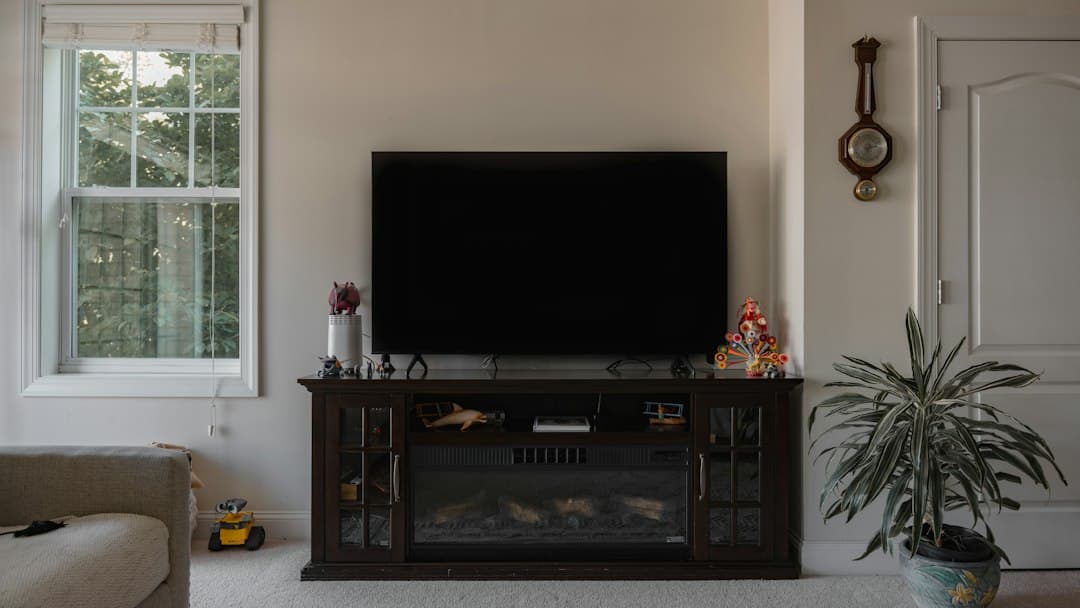 A bright living room with a wall-mounted television and plants, ready to stream Varesteam4K IPTV